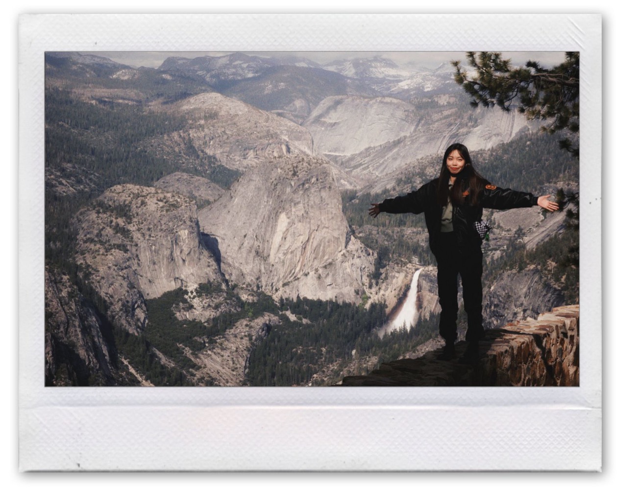 Zhixin Wang standing on a rock overlooking a canyon, in a polaroid frame